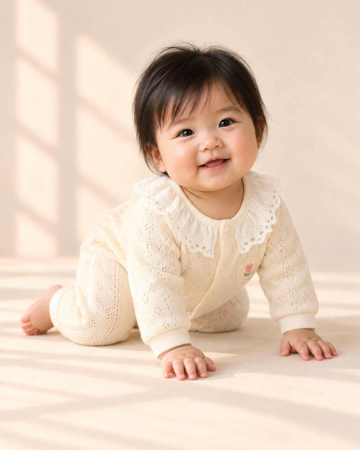 Baby smiling in the lace collar knit romper – Cream