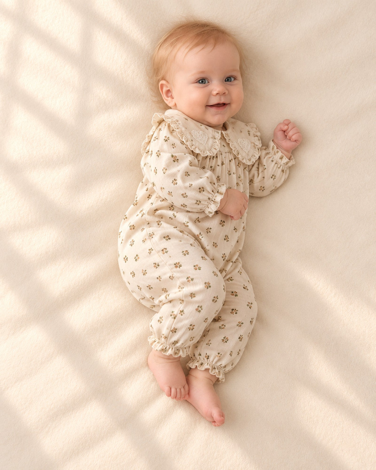 Side view of the ruffle collar romper on a smiling baby – Cream Floral