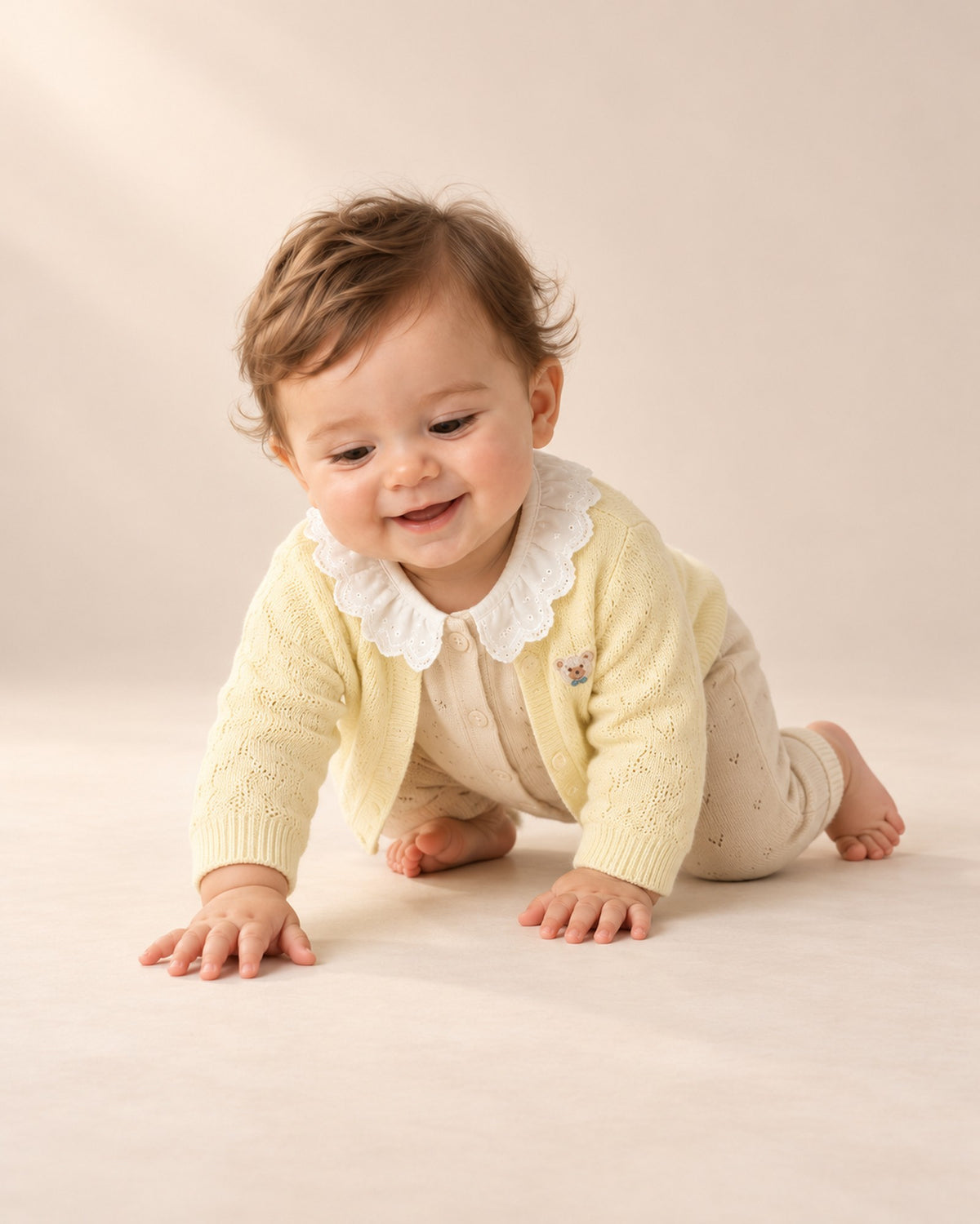 Baby crawling in the oatmeal pointelle jumpsuit and yellow cardigan – Oatmeal