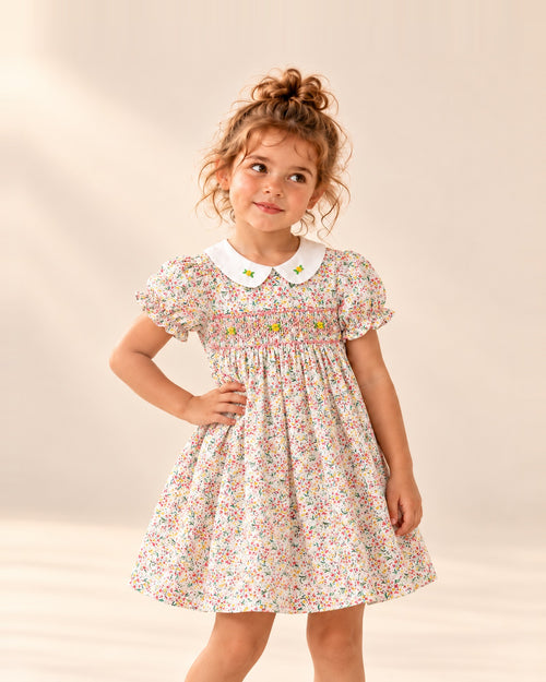 Girl in the Rosie smocked floral dress with a white Peter Pan collar, hand on hip – Pink Floral