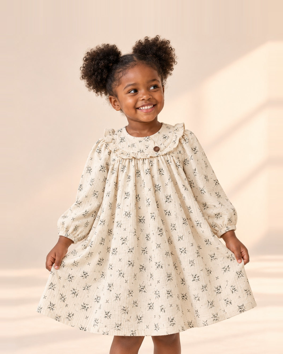 Girl holding out the skirt of the Iris cream leaf print dress – Cream