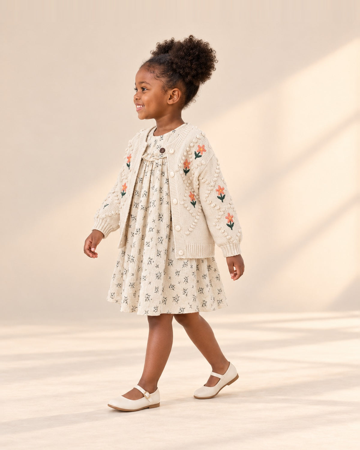 Side view of the leaf print dress with a ruffled yoke worn with the embroidered flower knit cardigan – Cream