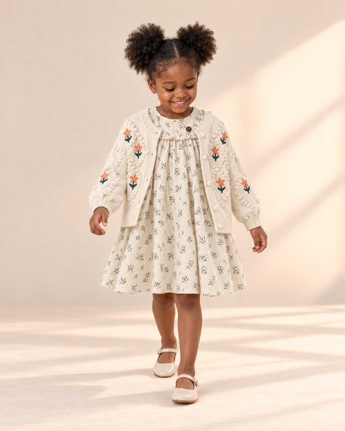 Girl at play in the leaf print dress with a ruffled yoke, styled with the embroidered flower knit cardigan – Cream
