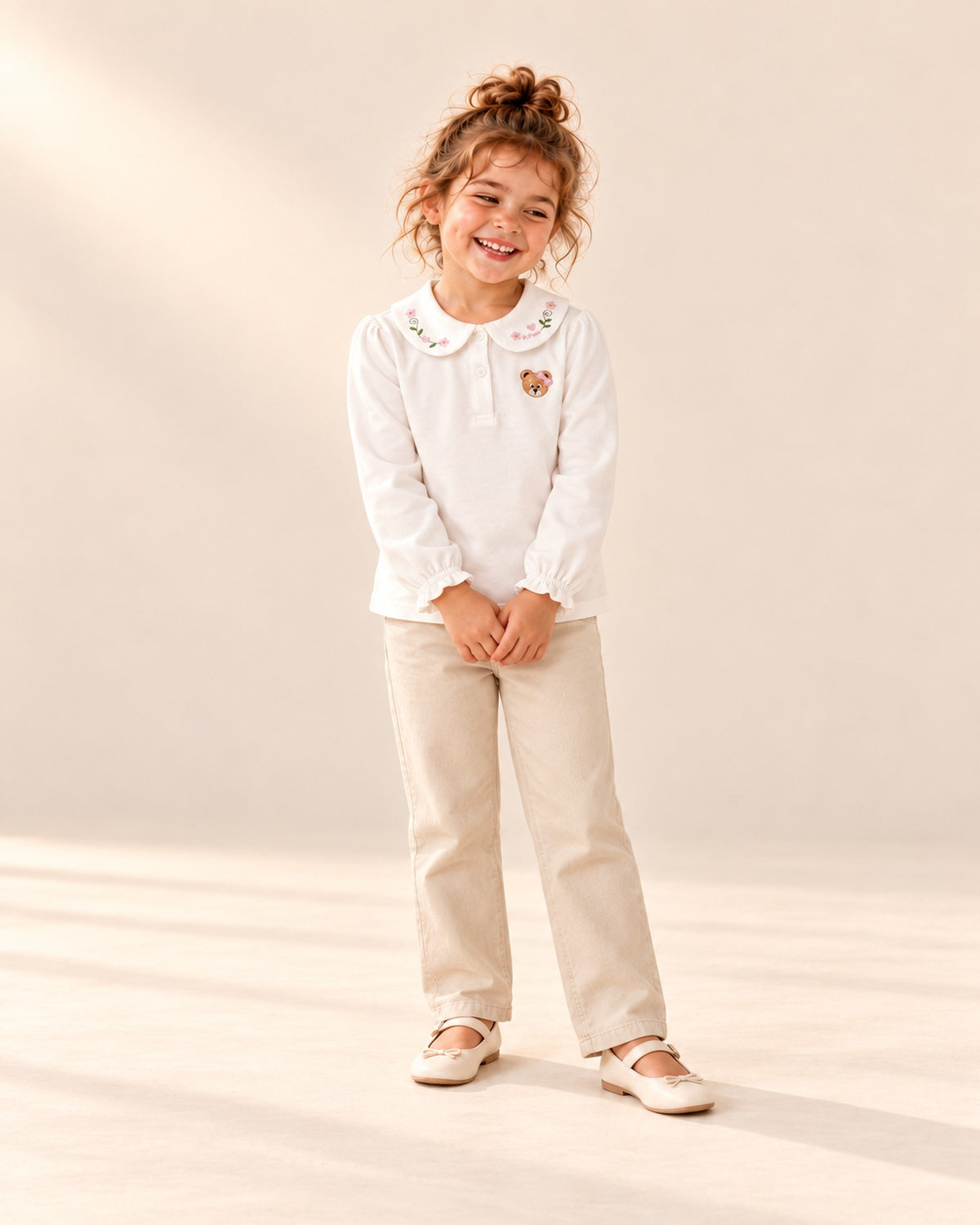 Front view of a girl in the white bear collar top under a brown corduroy pinafore dress, full length – White