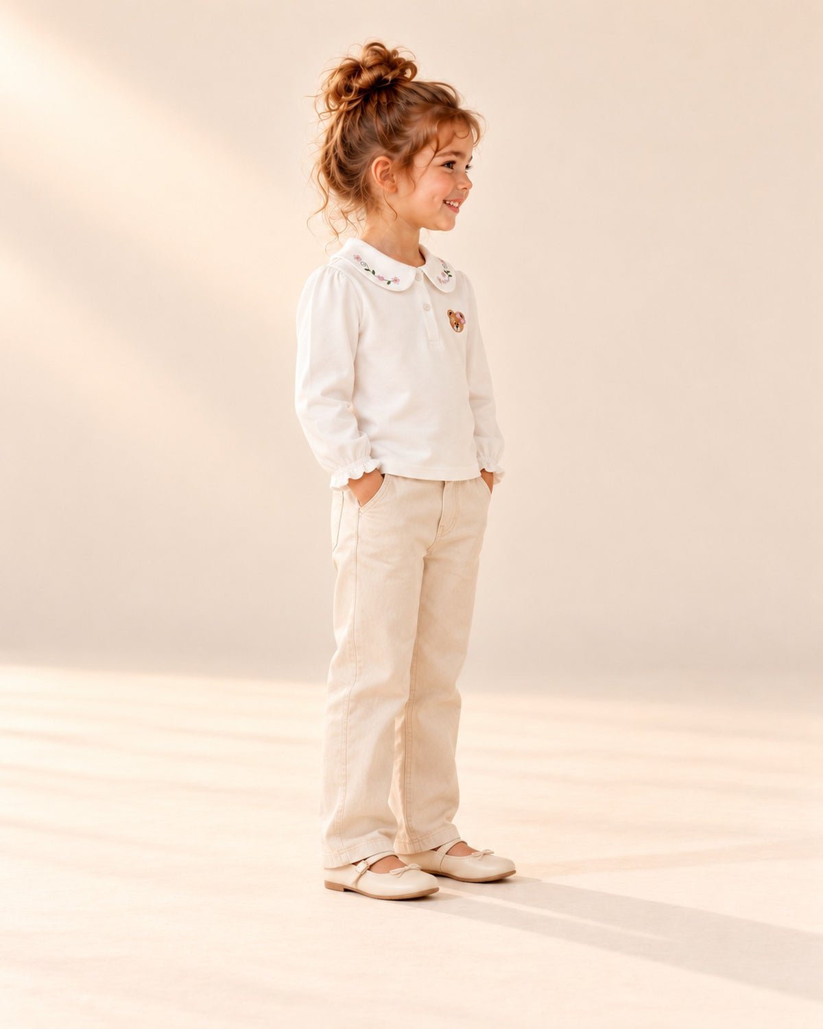 Side view showing the ruffled cuff and puffed sleeve of the white top under the pinafore – White