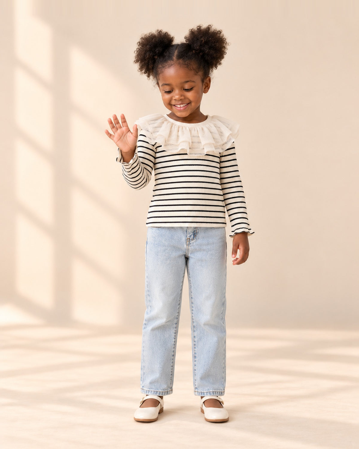 Front view of a girl in the striped ruffle collar top with light-wash straight jeans, full length – Black Stripe