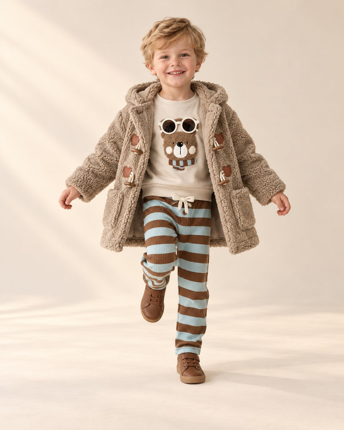 Boy skipping in the striped pants set and teddy duffle coat – Oatmeal