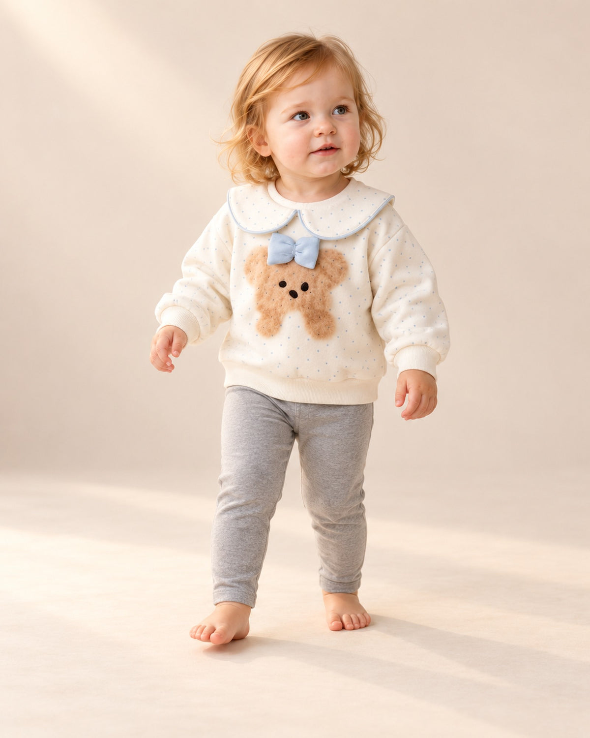Toddler walking in the cream sweatshirt with blue bow – Cream