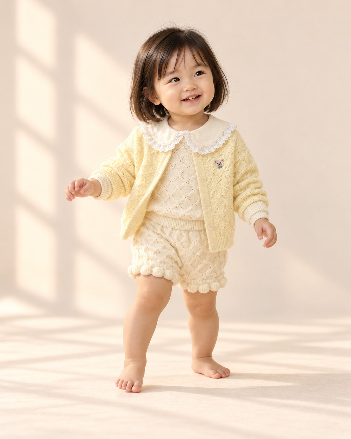 Toddler at play in the butter knit bear cardigan, styled with the popcorn knit set with lace collar – Butter Yellow