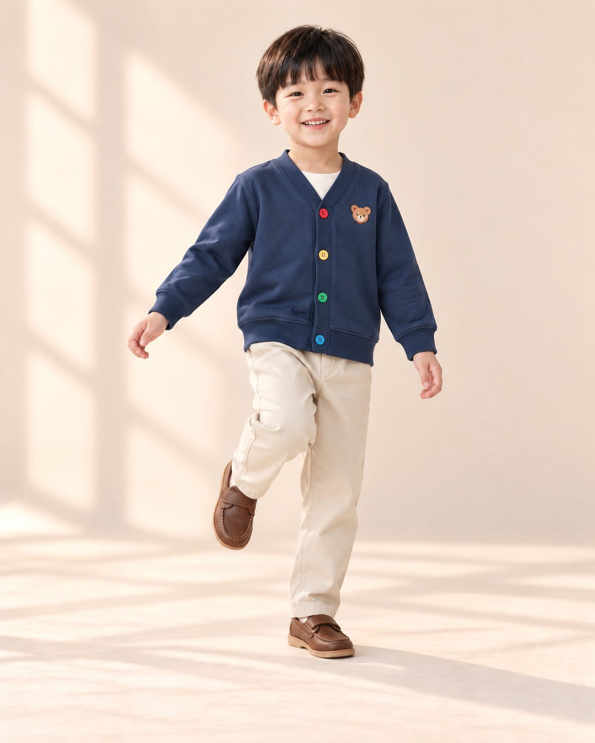 Boy kicking up a foot in the navy bear cardigan – Navy