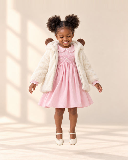Girl turning with the hood up on the cream teddy coat – Cream