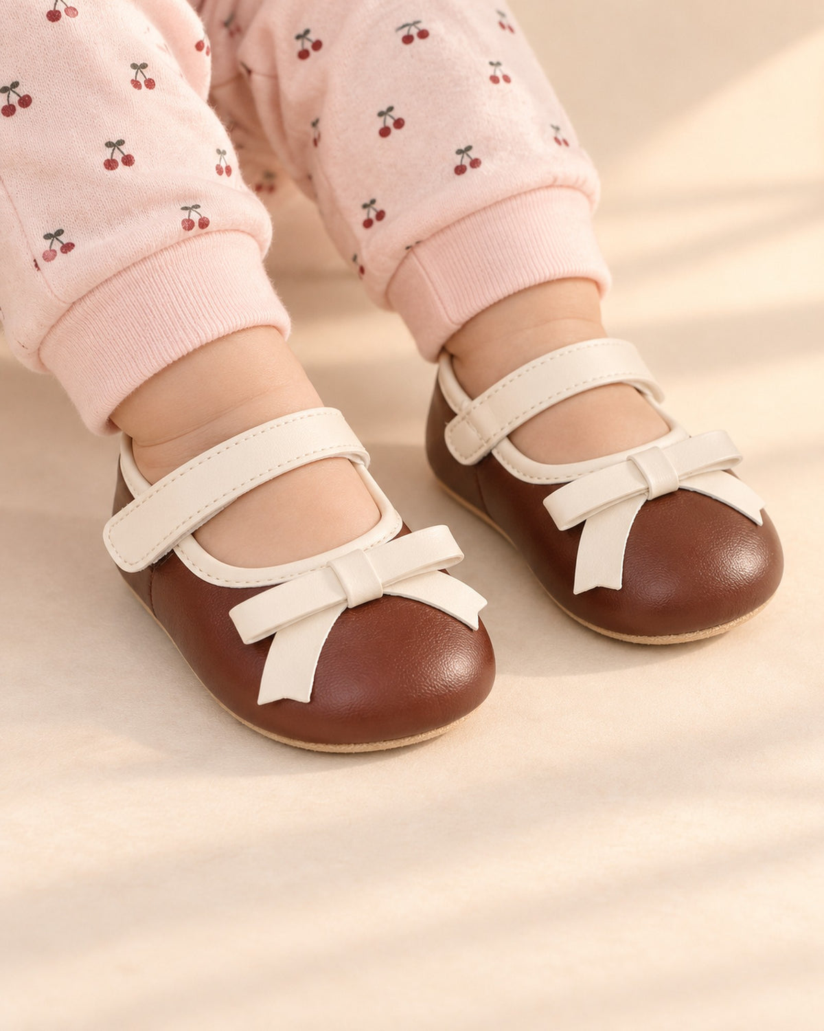 Close-up of brown baby pre-walkers with a cream bow and strap – Brown