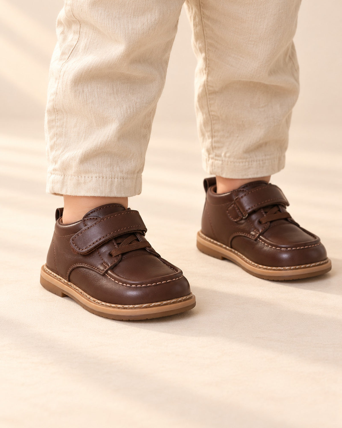 Close-up of glossy brown leather-look toddler shoes with a hook-and-loop strap – Brown
