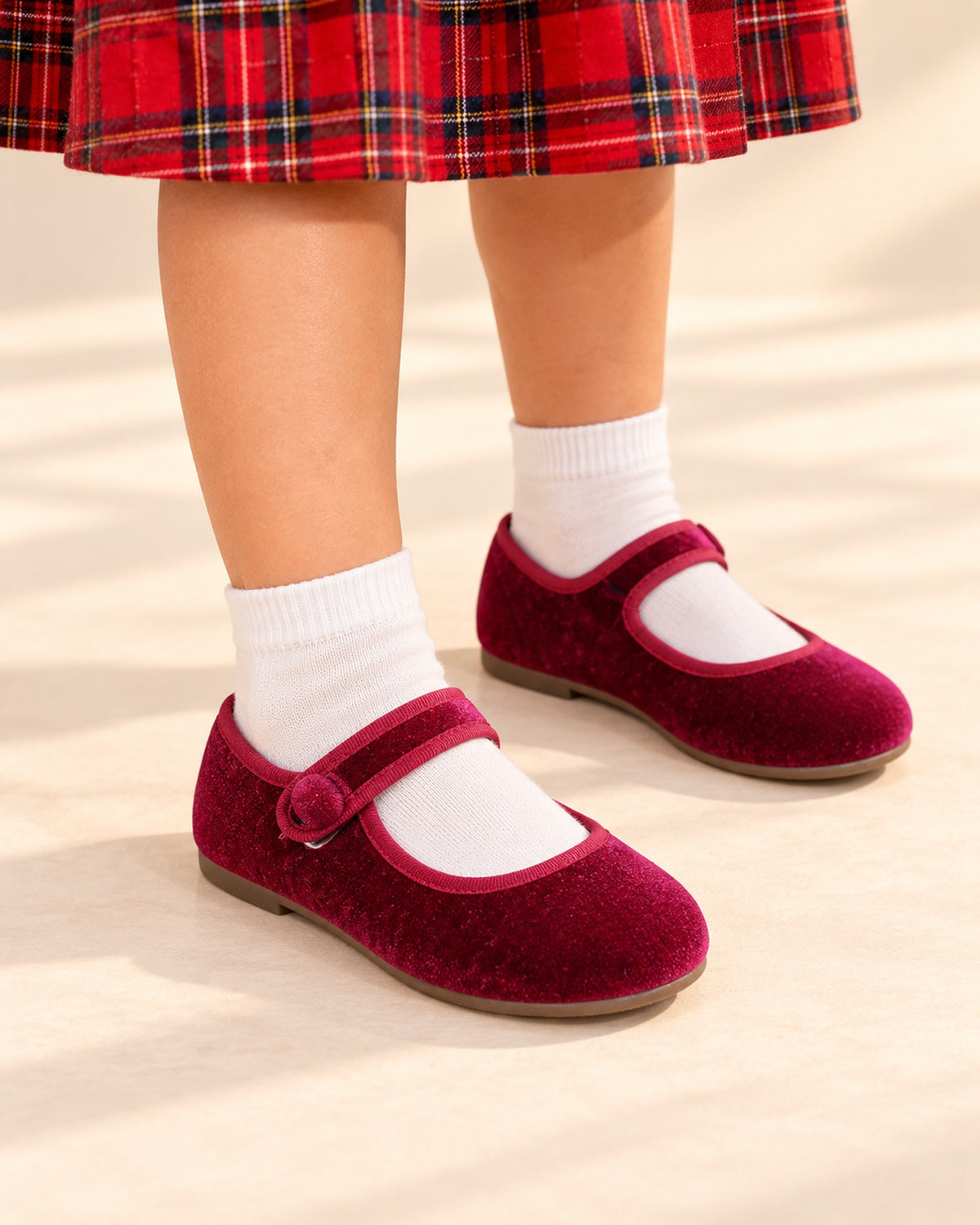 Close-up of a girl's feet in burgundy velvet Mary Janes with a single button strap – Burgundy