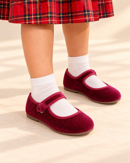 Close-up of a girl's feet in burgundy velvet Mary Janes with a single button strap – Burgundy