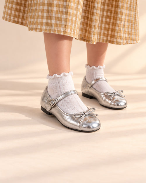 Close-up of silver metallic Mary Jane flats with toe bows and buckle straps – Silver
