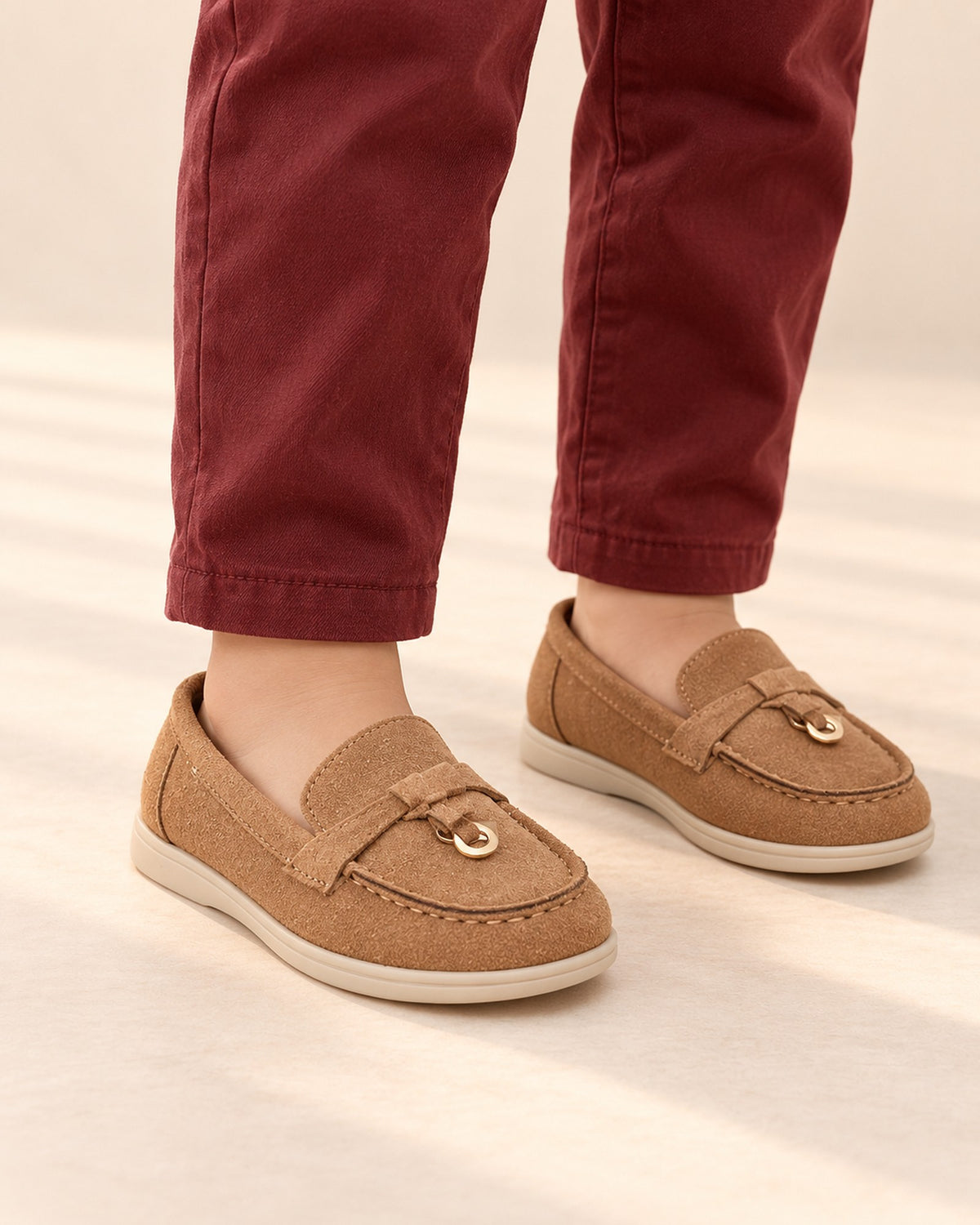 Close-up of a boy's feet in tan suede-look loafers with a gold-tone ring on the strap – Tan