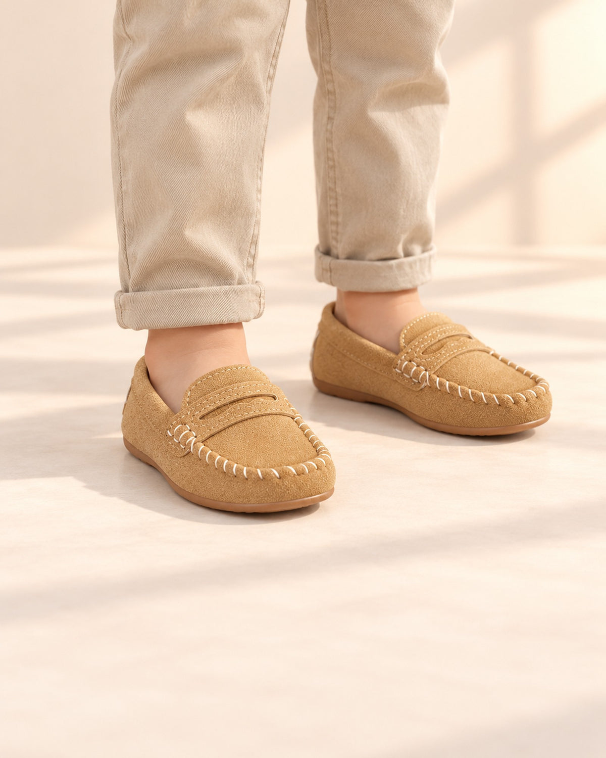 Close-up of tan suede-look penny loafers with a stitched moccasin toe – Tan