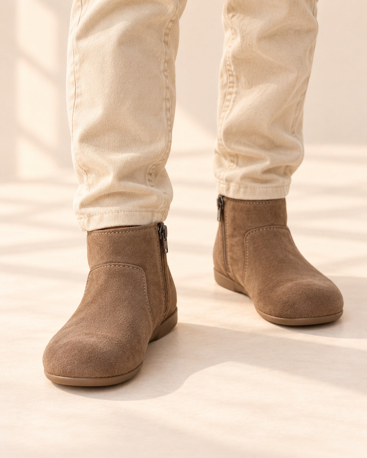 Close-up of a boy's feet in taupe-brown suede-look ankle boots with an inner zip – Brown