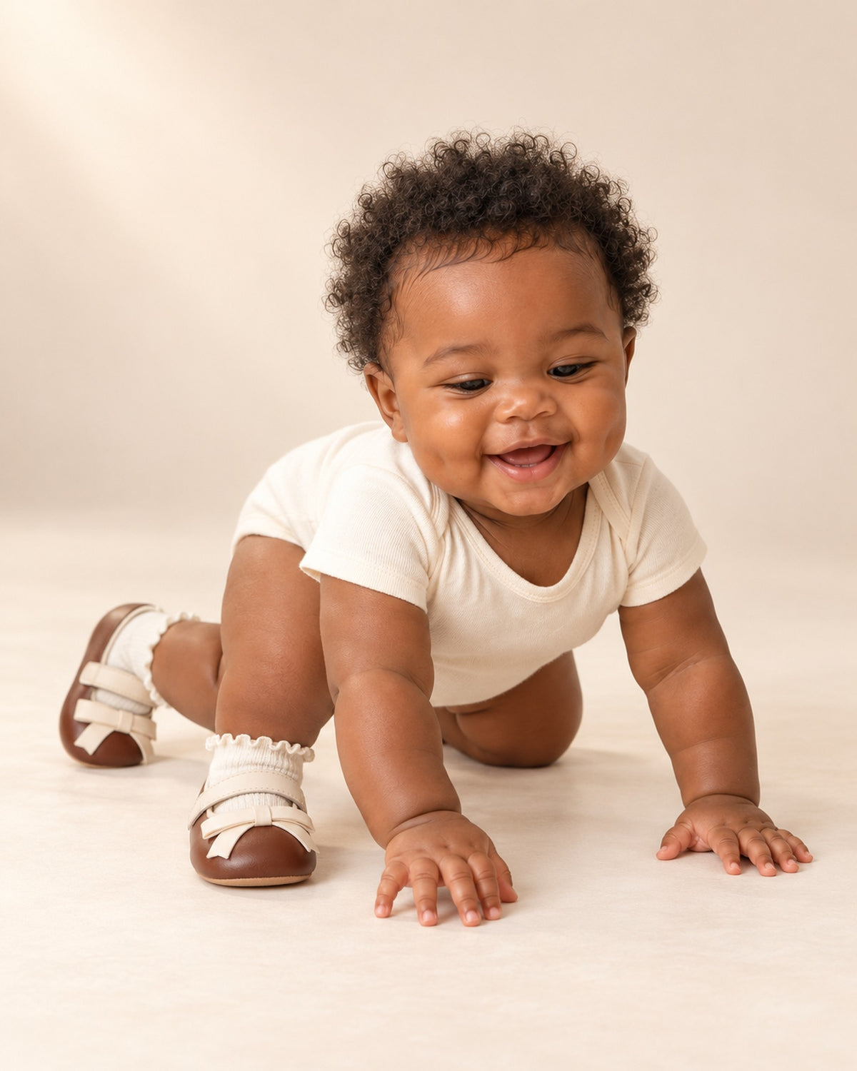 Baby in a cream romper with the frill socks and bow shoes, head to toe – White