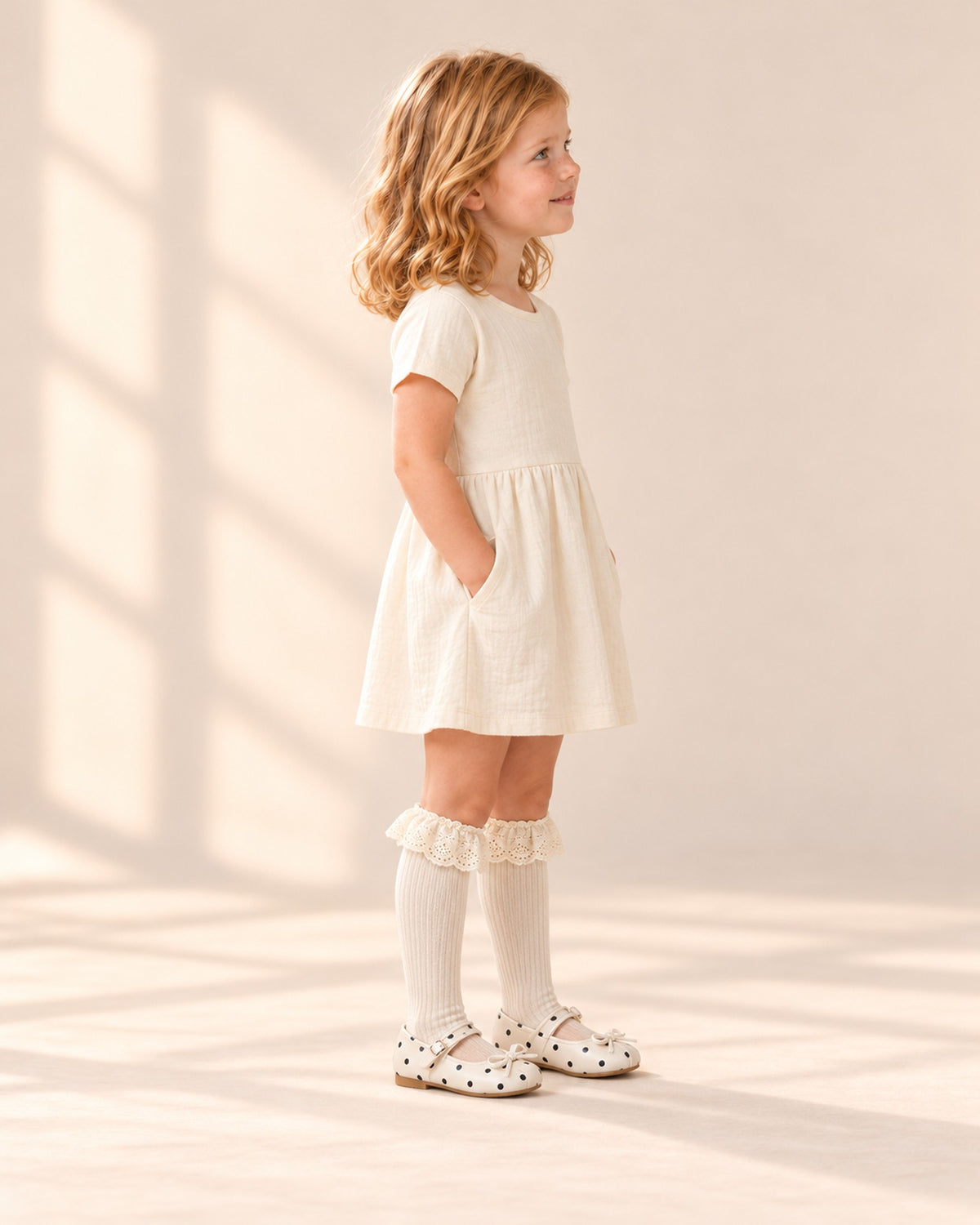 Side view of the eyelet ruffle sock above a polka dot Mary Jane – Cream