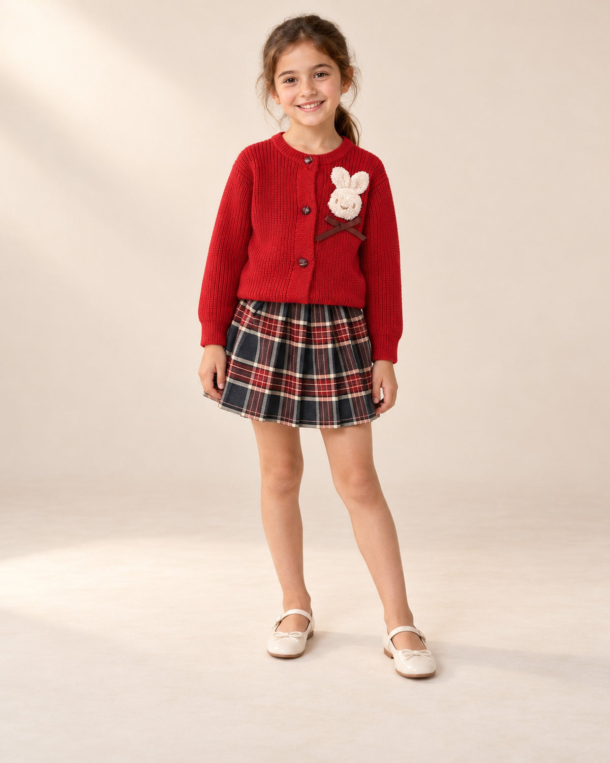 Front view of the red cardigan and pleated tartan skirt – Red