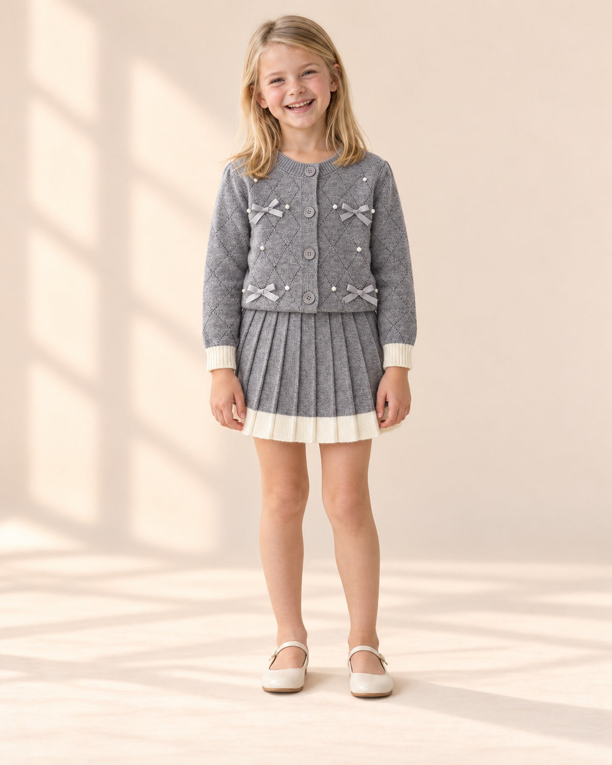 Front view of the gray pearl bow cardigan and pleated skirt set – Grey