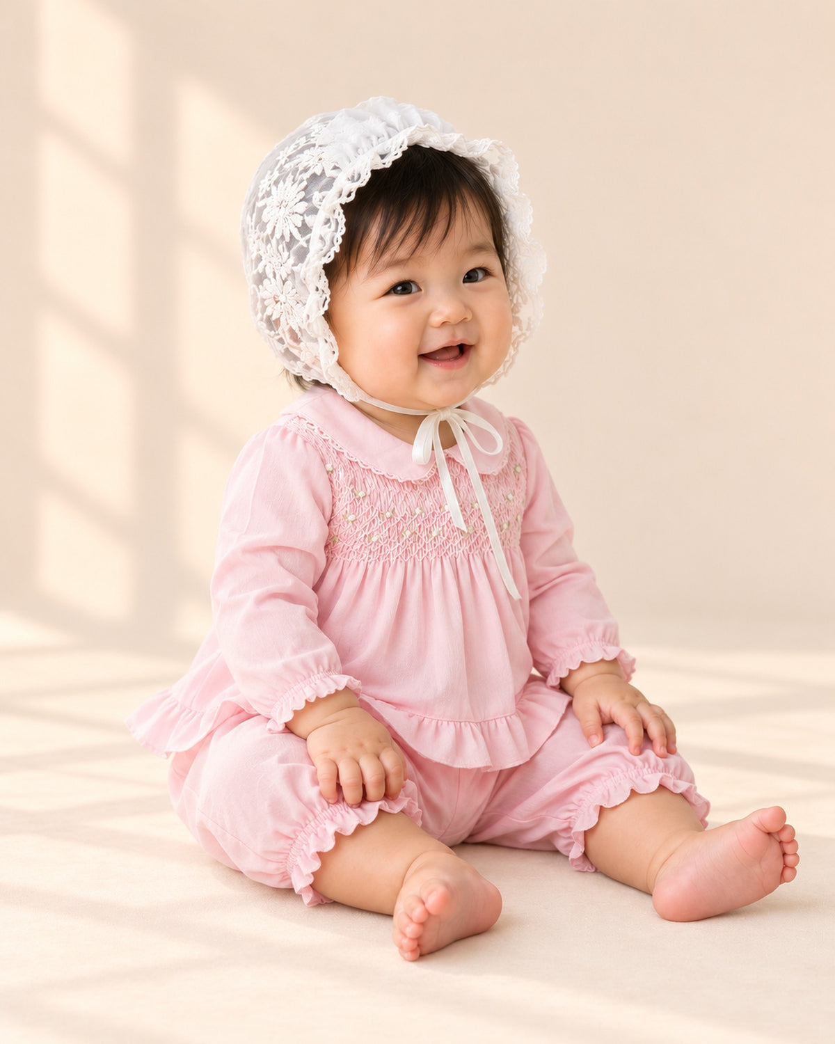Side view of the pink smocked top and ruffle bloomers with the lace bonnet – Pink
