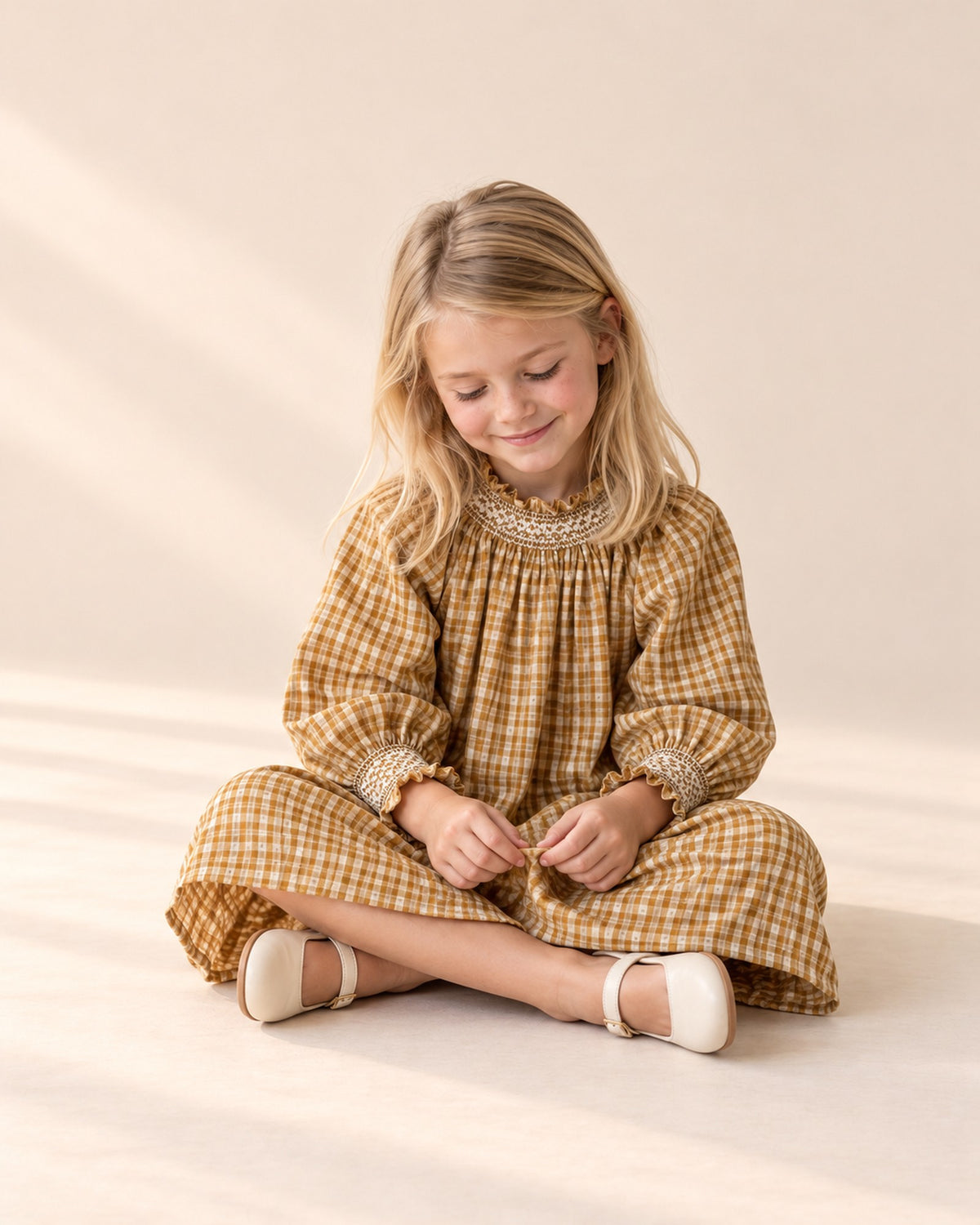 Girl sitting cross-legged in the ochre check dress – Ochre Check