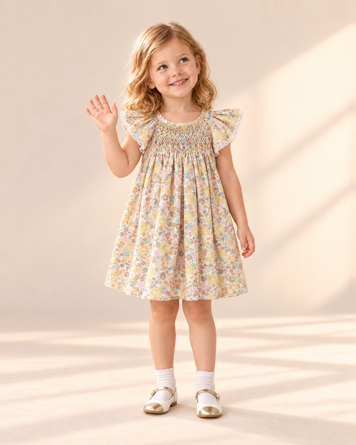 Front view of a girl in the yellow floral smocked dress, white ankle socks and pearl strap Mary Janes, full length – Yellow Floral