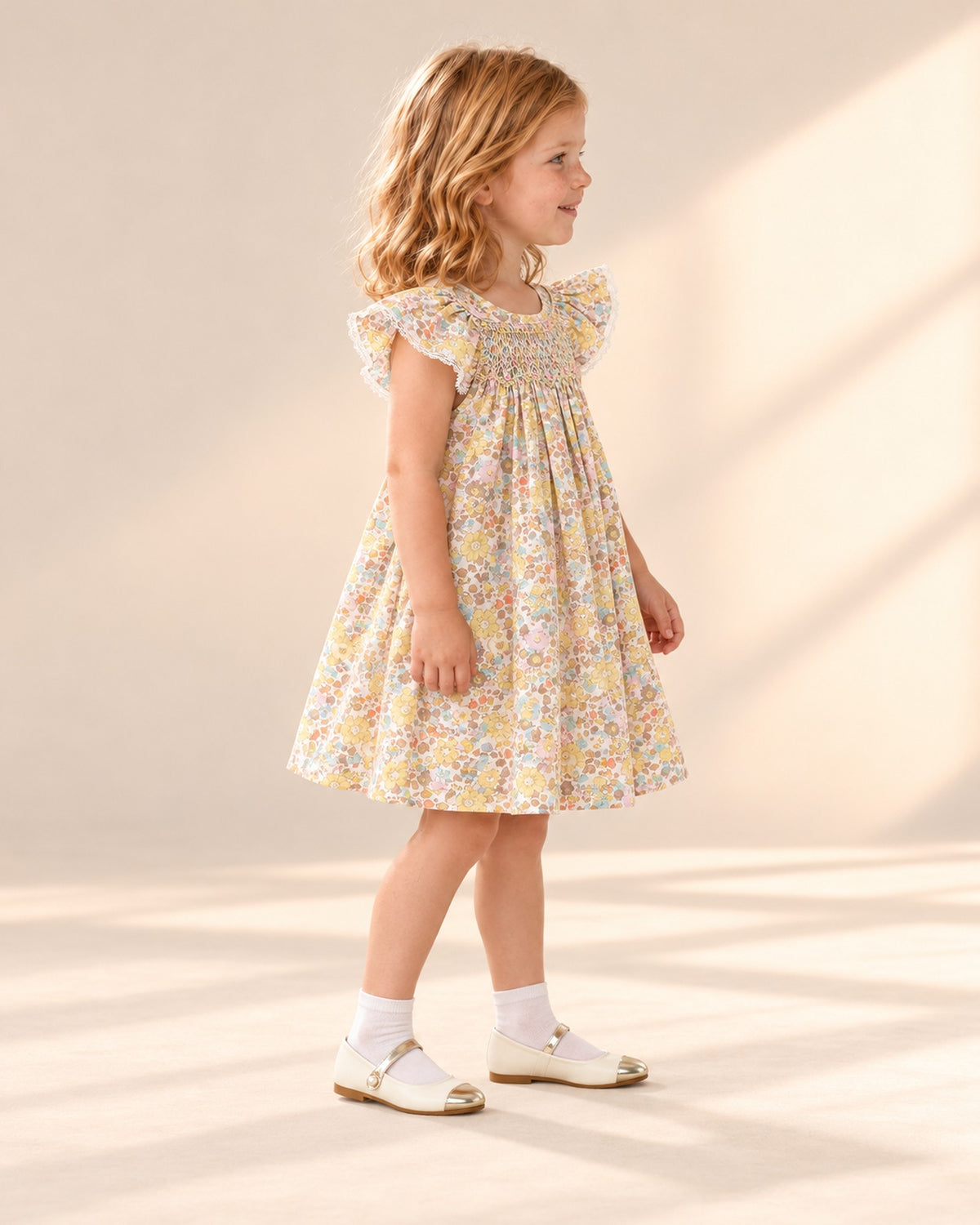 Side view of the flutter sleeve and smocked chest of the yellow floral dress – Yellow Floral