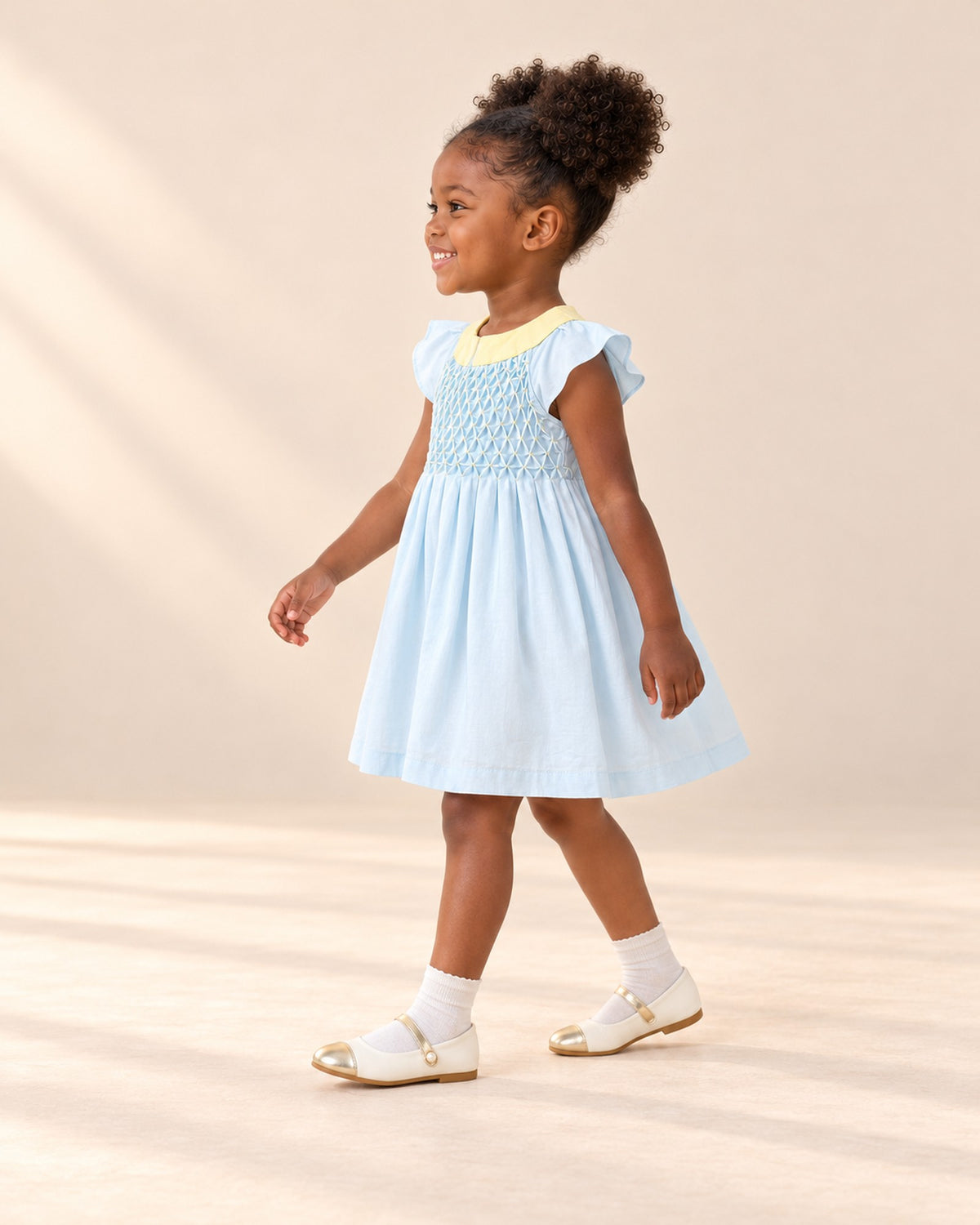 Side view of the blue dress showing the flutter sleeve and pleated skirt – Light Blue