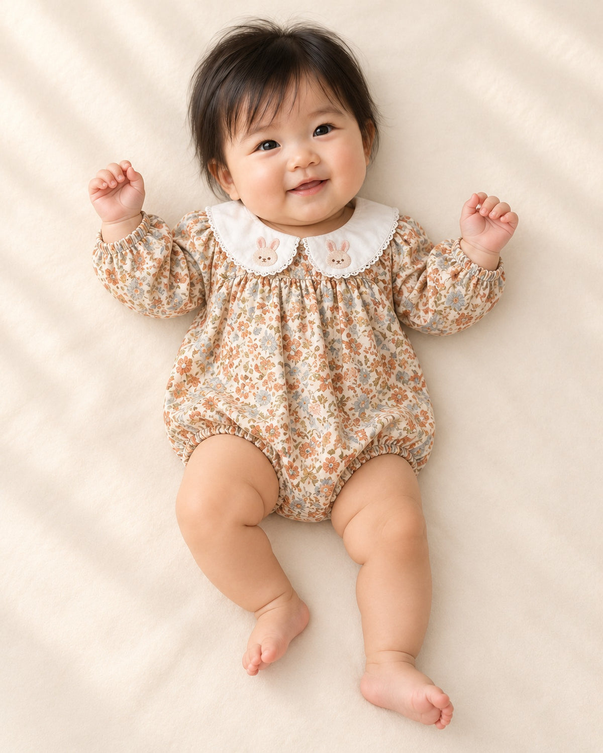 Front view of the floral bubble romper on a baby lying down – Vintage Floral