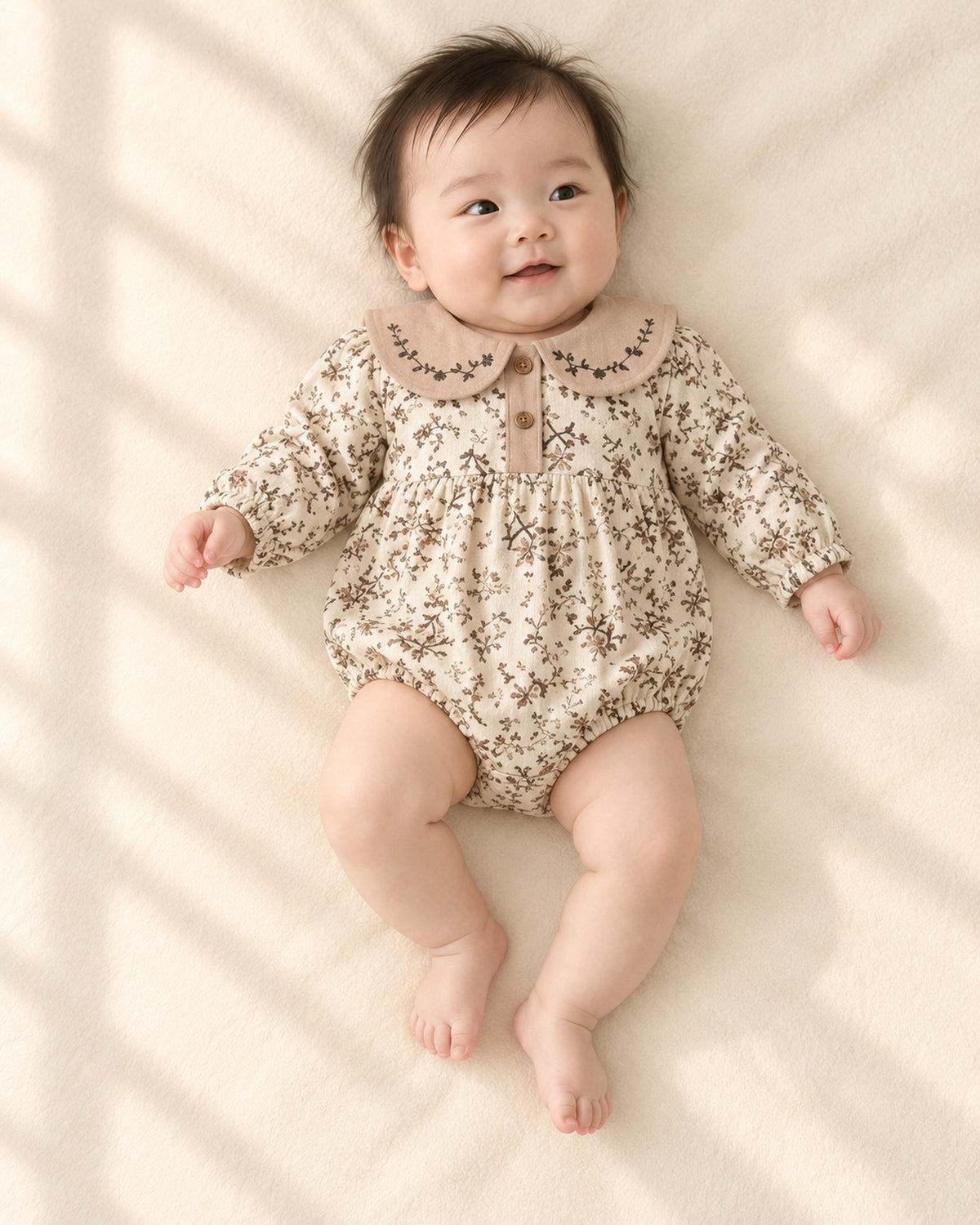 Front view of the brown floral bubble romper with button placket – Cream Floral