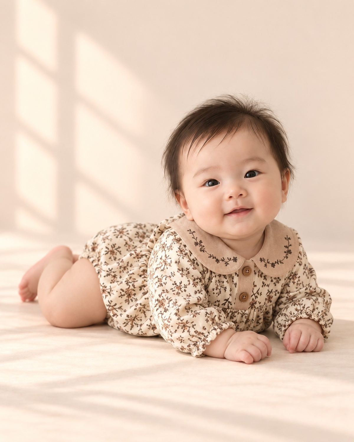 Baby on tummy in the vintage floral romper – Cream Floral