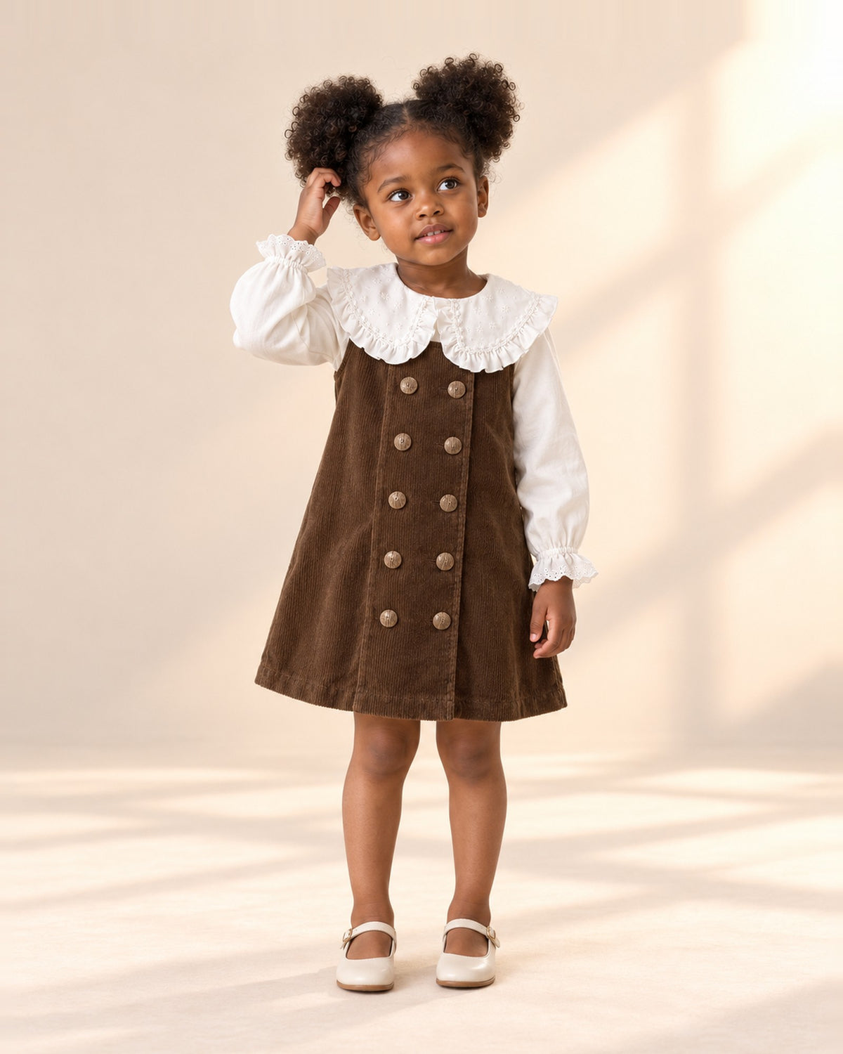 Full-length front view of the corduroy pinafore dress, paired with the ruffle collar blouse – Chocolate Brown