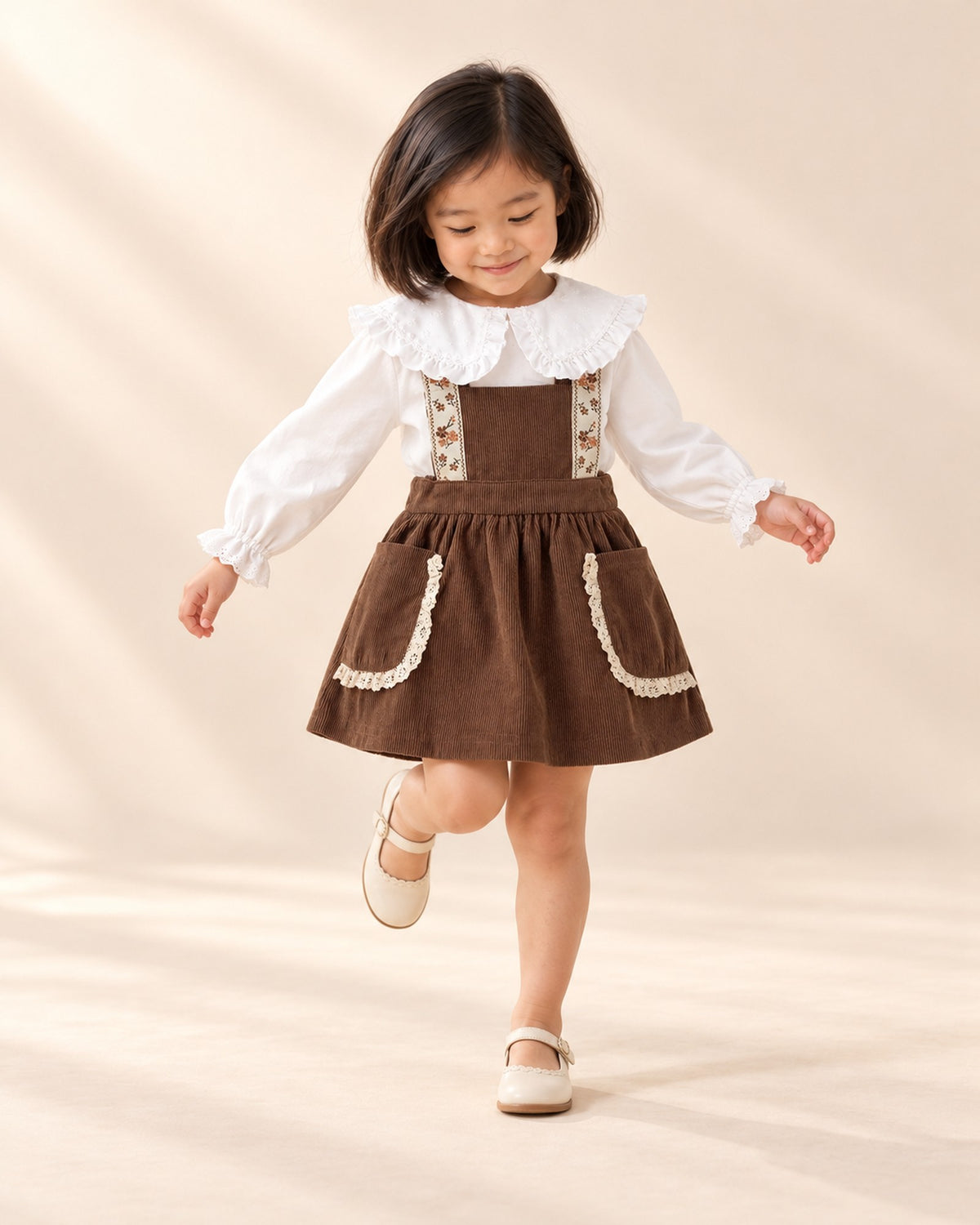 Sylvie Lace Pocket Corduroy Pinafore in Chocolate – natural pose