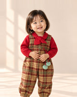 Toddler smiling in the Birdie tartan overalls and red knit top – Tartan