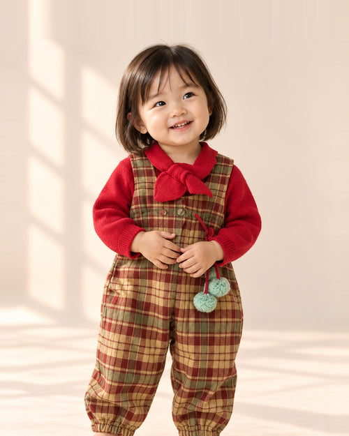 Toddler smiling in the Birdie tartan overalls and red knit top – Tartan