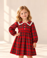 Girl in the Libby red tartan dress with a white lace collar, hand on hip – Red Tartan