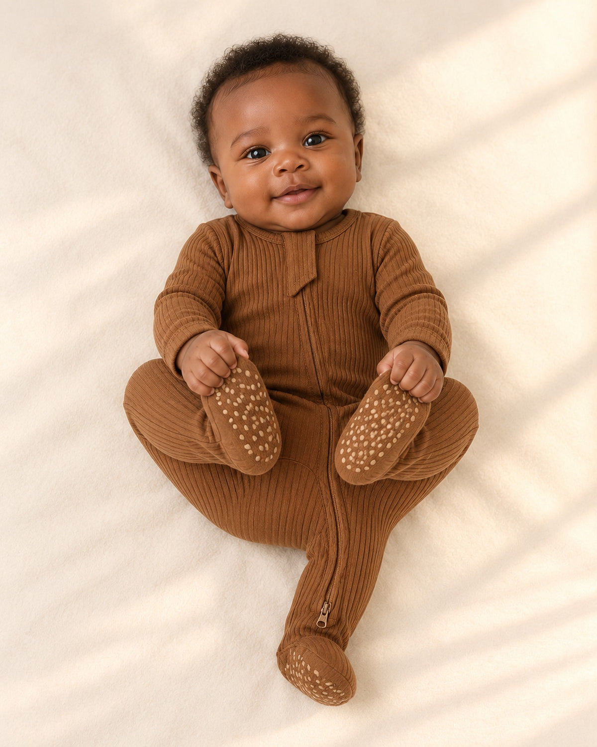 Cubby Ribbed Zip Footie in Caramel – natural pose