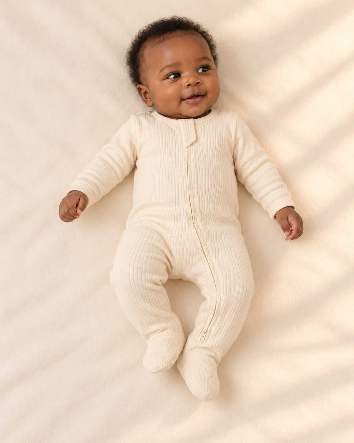Cubby Ribbed Zip Footie in Cream – full front view