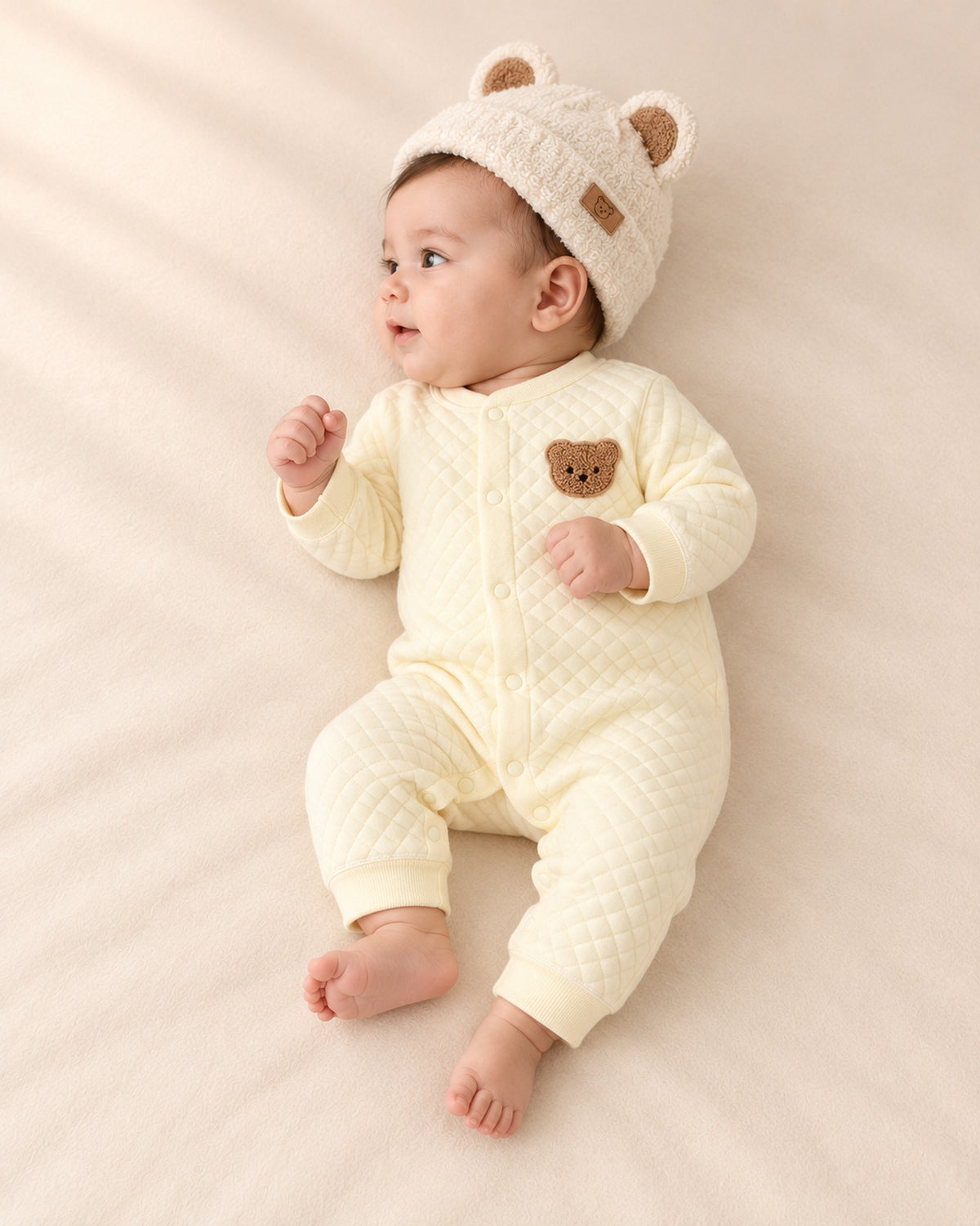 Side view of the quilted romper showing the snap front and ribbed ankle bands – Butter