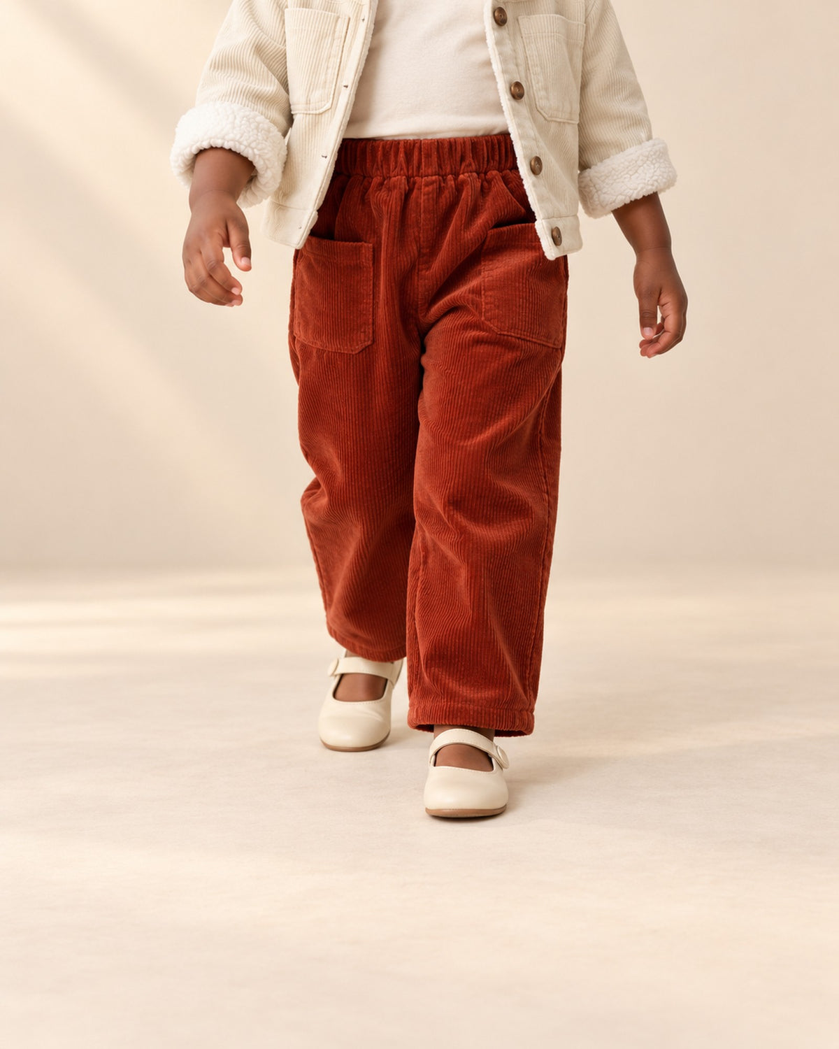 Close-up from waist to feet of rust red corduroy pants with large side patch pockets – Rust