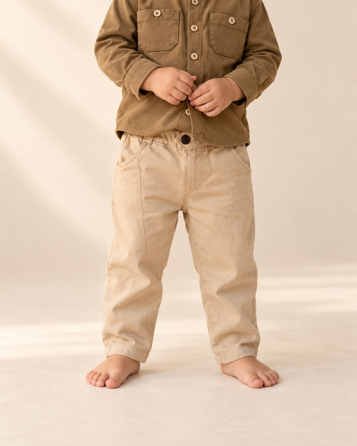 Close-up from chest to feet of khaki pull-on chinos with an elastic waist and front button – Khaki