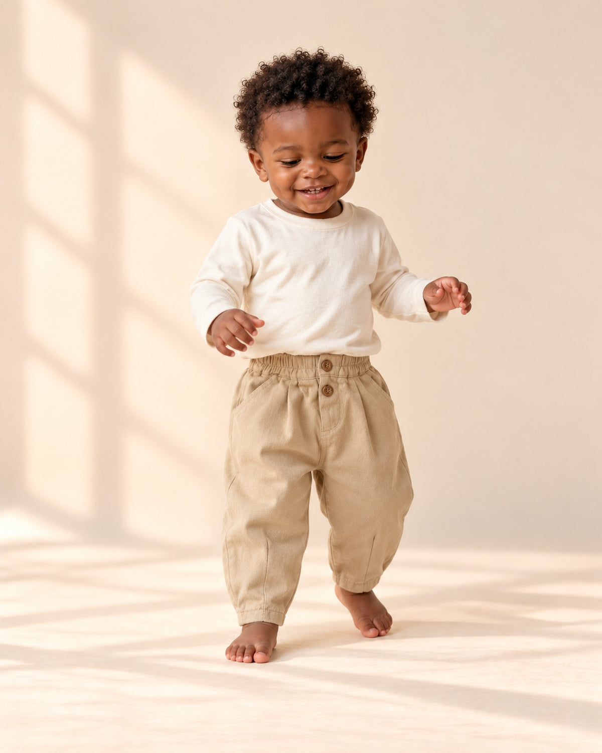 Toddler crouching to play in the khaki balloon pants and cream tee – Khaki