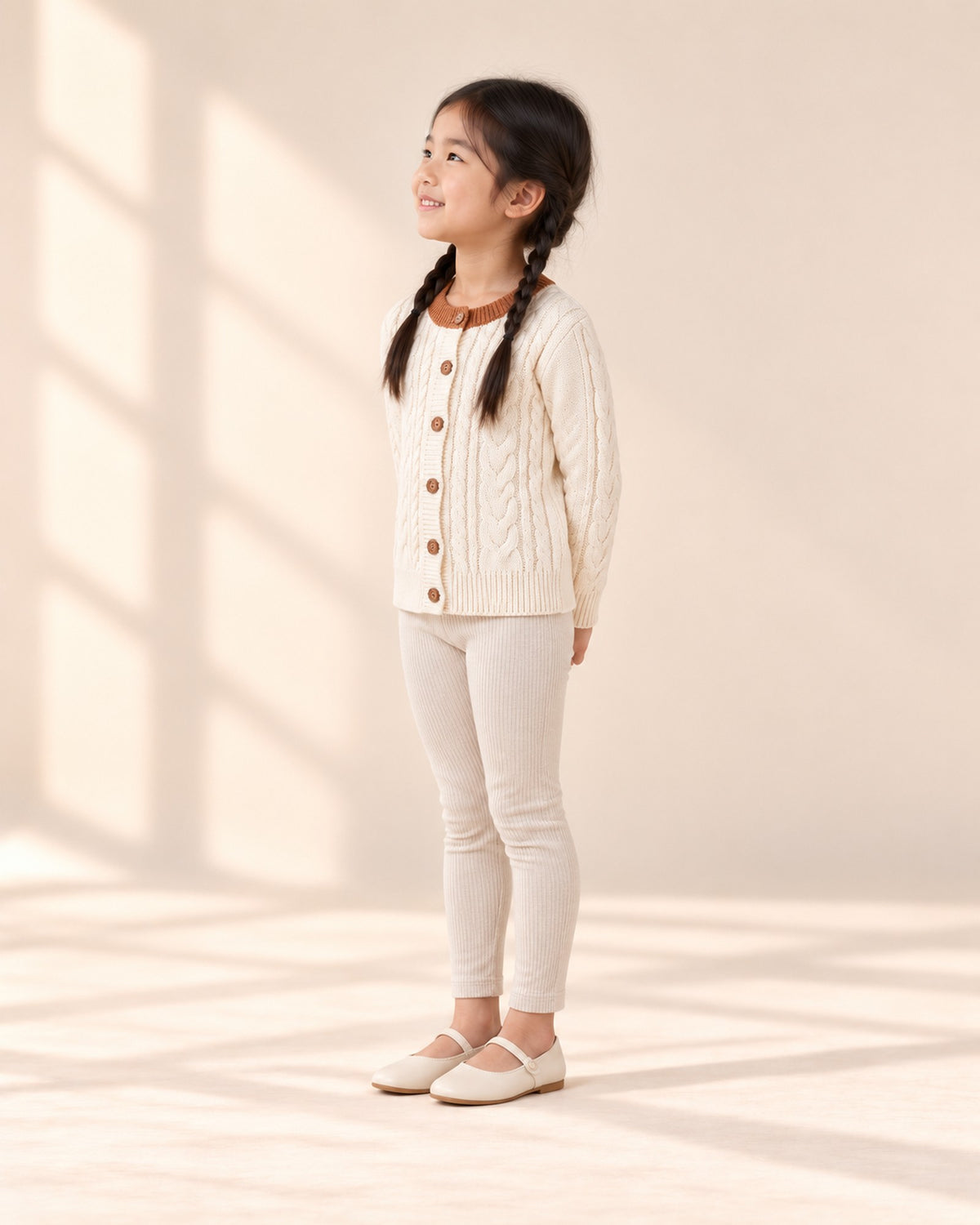 Side view of the fitted oatmeal leggings with the cream cable cardigan – Oatmeal