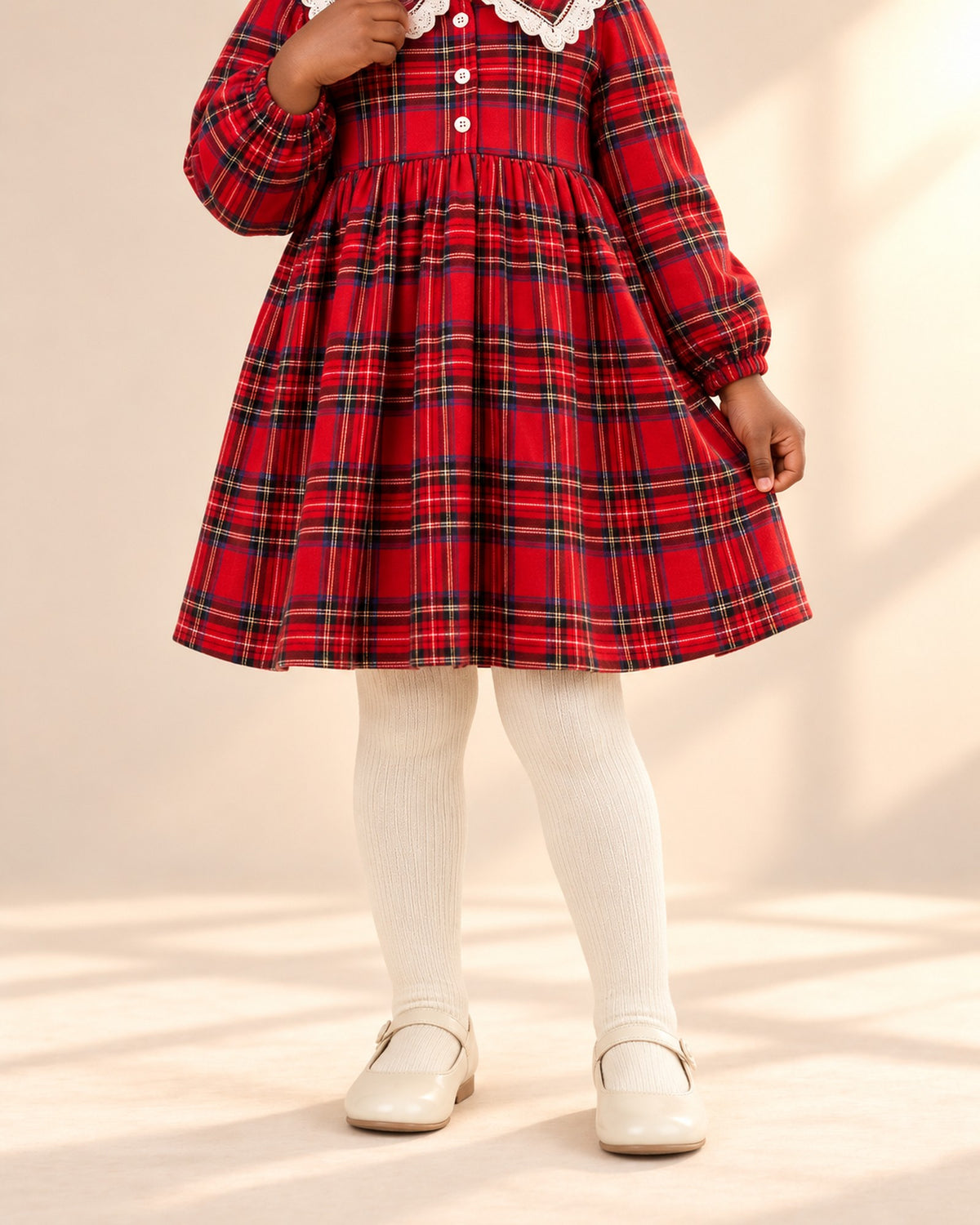 Close-up from chest to feet of cream ribbed tights worn under a red tartan dress – Cream