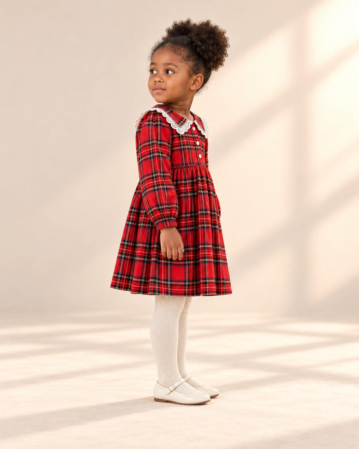 Side view showing the fine ribbing of the cream tights below the tartan hem – Cream