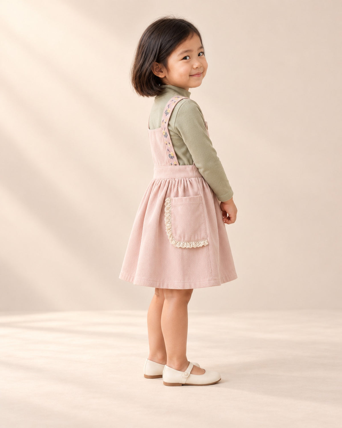 Side view of the sage top sleeves with the pink pinafore – Sage